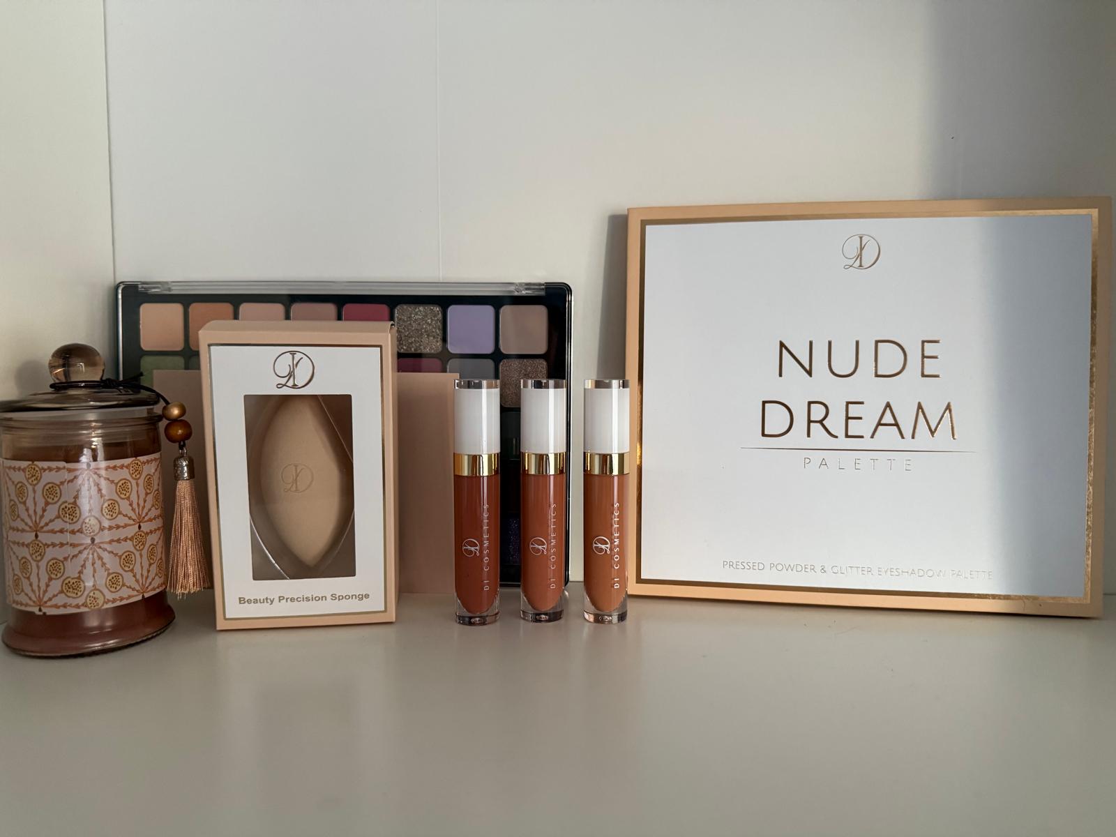 Kosmetikartikel wie Lidschattenpaletten, Lippenstifte und Schwamm in warmen Farben