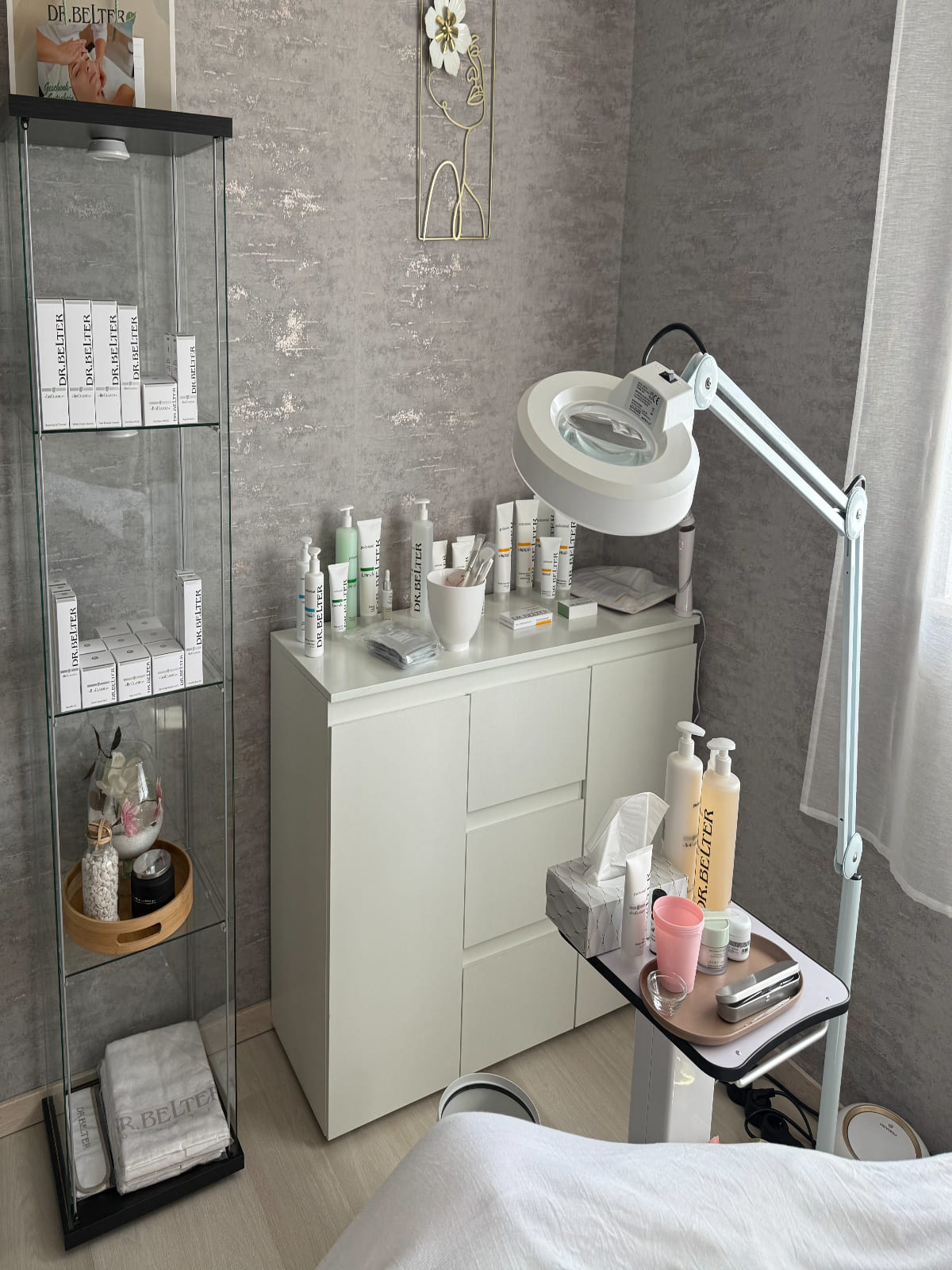 Ein heller Raum mit Kosmetikprodukten, moderner Lampe und Glasvitrine